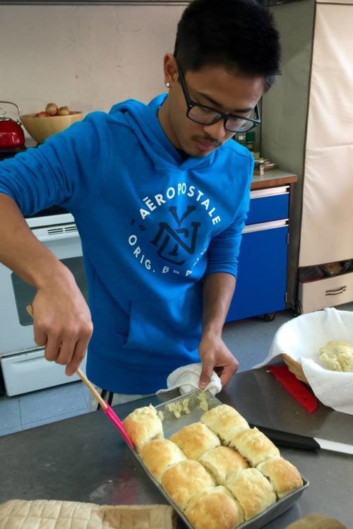 An Earn2Learn teen takes a biscuit cooking test for certification.