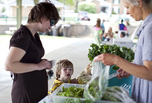 A mother and son at a farmers market booth